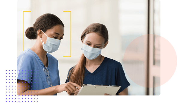 Nurses in masks looking at tablet